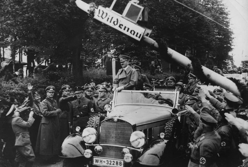 Adolf Hitler stands up in his car to acknowledge his welcome as he crosses the frontier into Sudetenland.