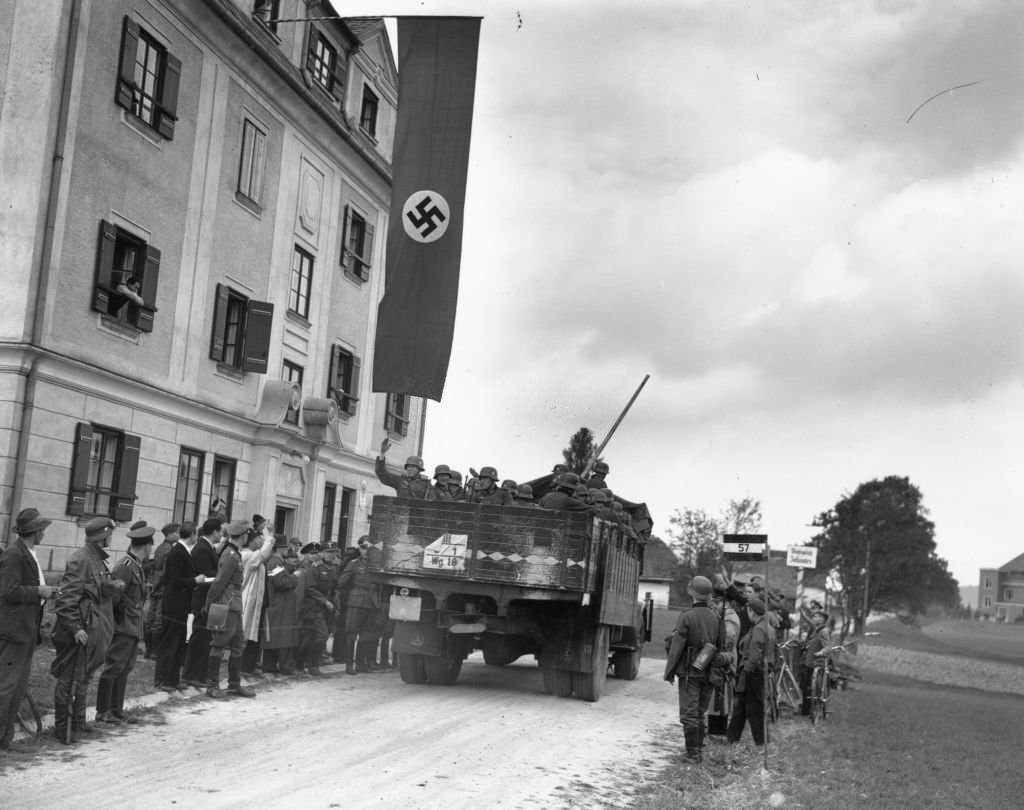 German armoured vehicles pass through a customs barrier between Germany and Czechoslovakia.