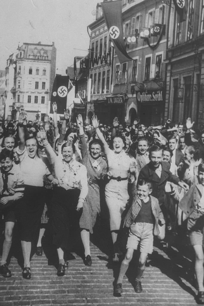 Women and young boys celebrating the German occupation of Asch, home of Konrad Henlein, leader of the Sudeten German party.