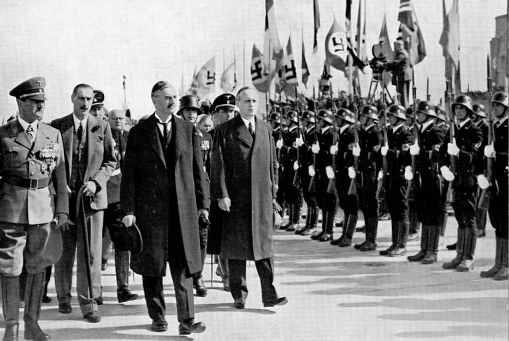 British Prime Minister Neville Chamberlain  passes a Germn honour guard on his arrival at Oberwiesenfeld airport before a meeting with Adolf Hitler over the latter’s threats to invade Czechoslovakia, 29th September 1938.
