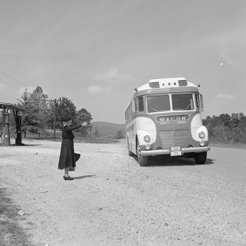 A woman hails a Macon-bound bus on a highway in Georgia.