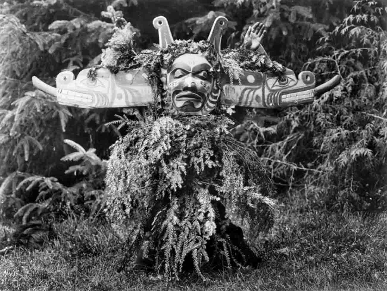 Sisiutl, one of the main dancers in the Winter Dance ceremonies, wearing a double-headed serpent mask and shirt made of hemlock boughs.