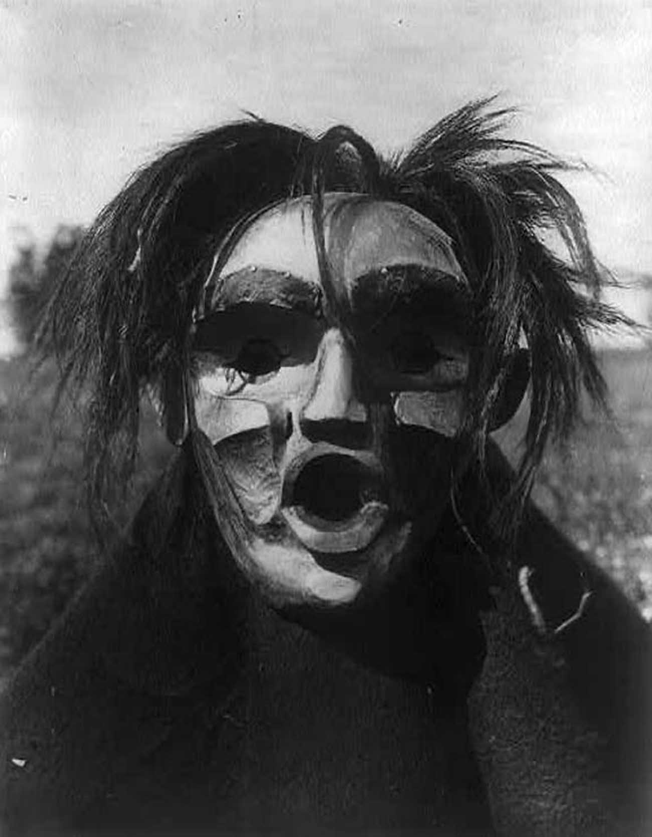 Person wearing Mask of Tsunukwalahl, a mythical being, used during the Winter Dance.