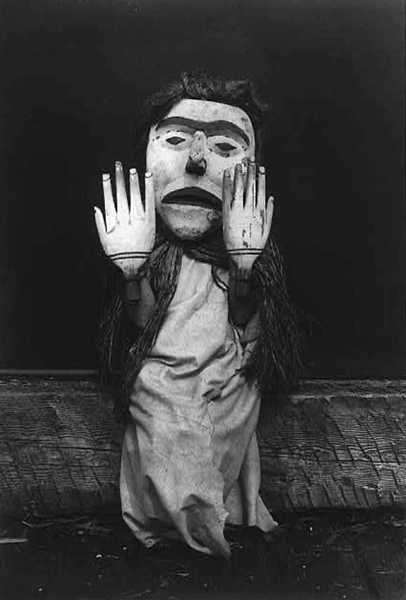 Kwakiutl person wearing an oversize mask and hands representing a forest spirit, Nuhlimkilaka, (“bringer of confusion”).