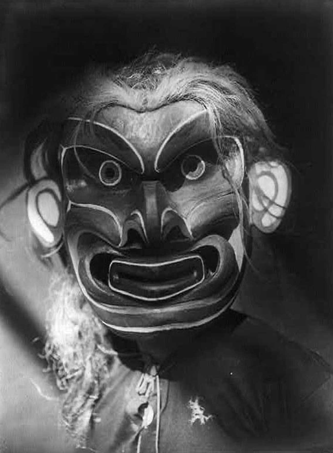 Kwakiutl person wearing the mask of mythical creature Pgwis (man of the sea).