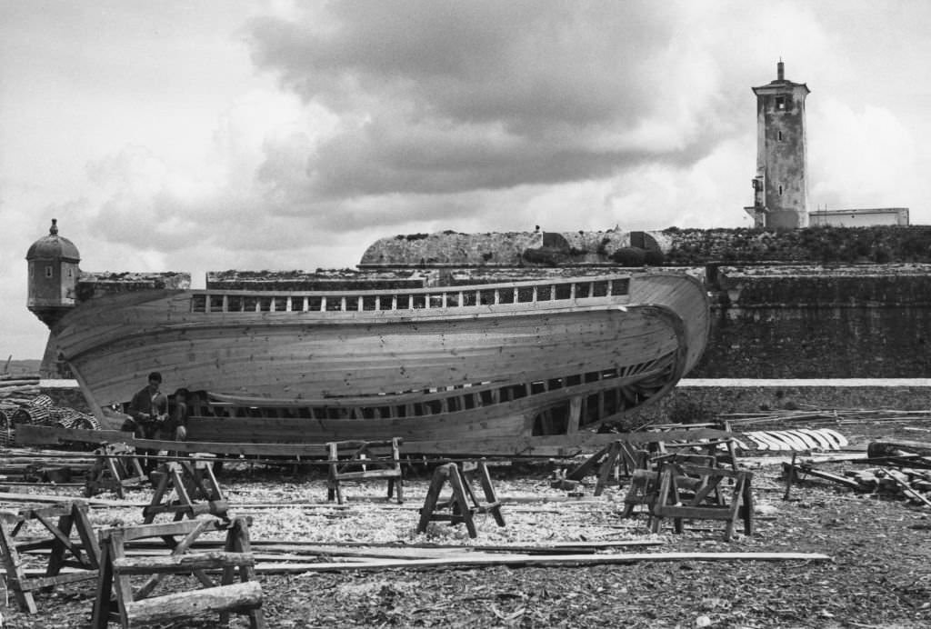 Construction of a fishing boat in Portugal a beach near Nazaré, Portugal, 1956.
