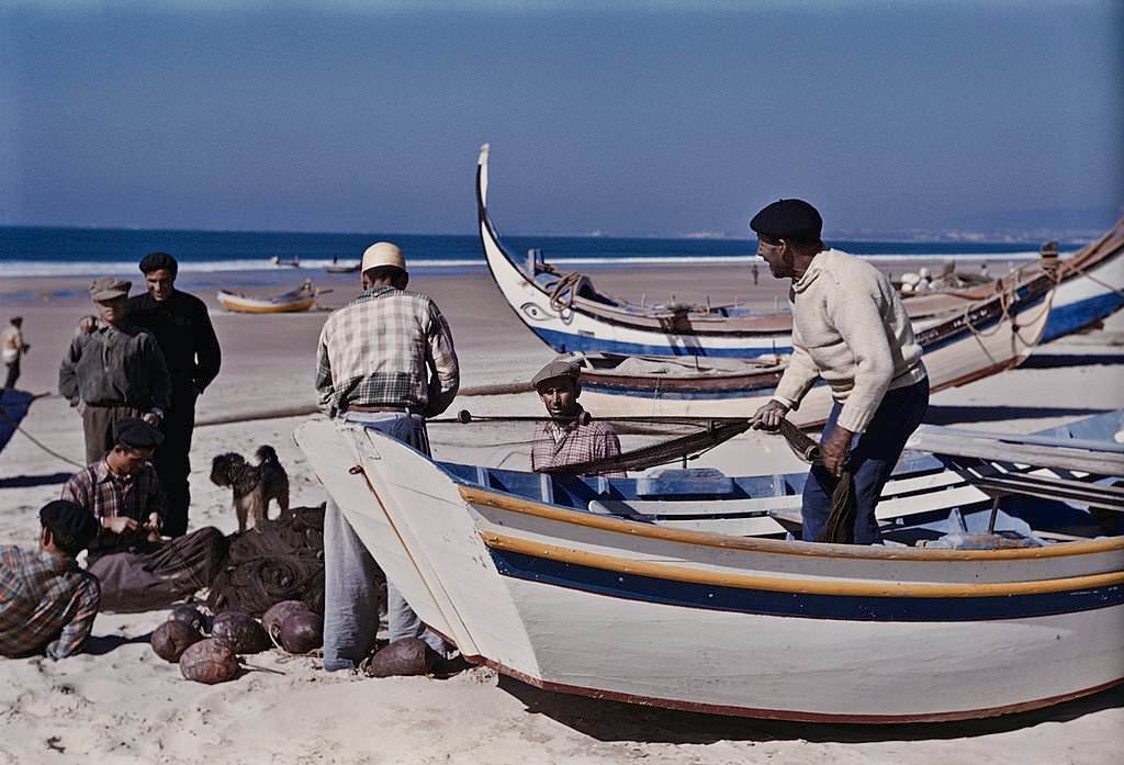 Fishermen with their boats on the beach at Nazare, Portugal, 1952.
