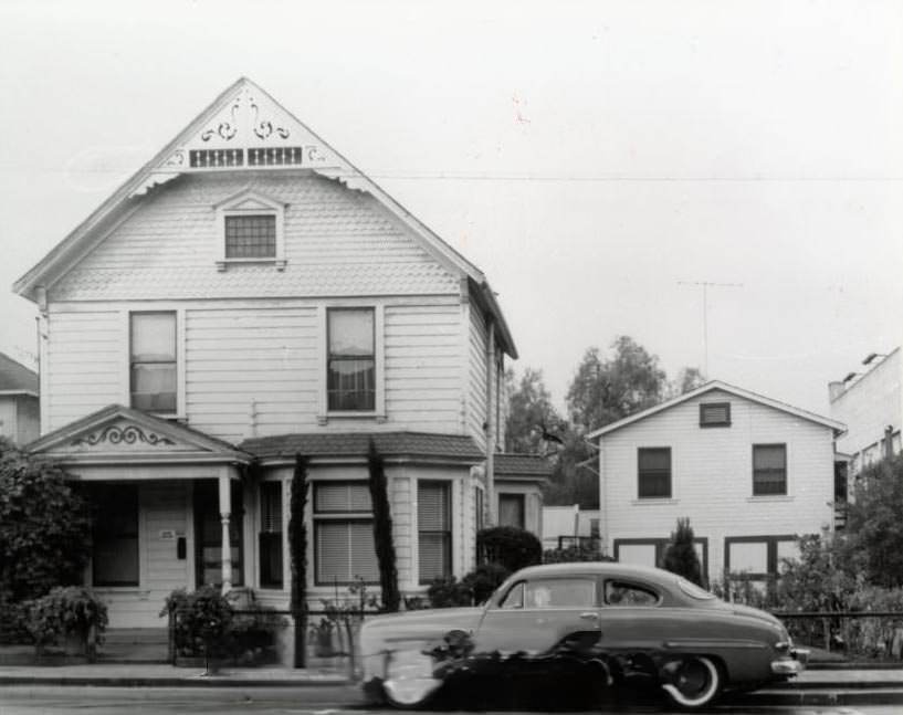 Large two-story home with car parked in front, 1940