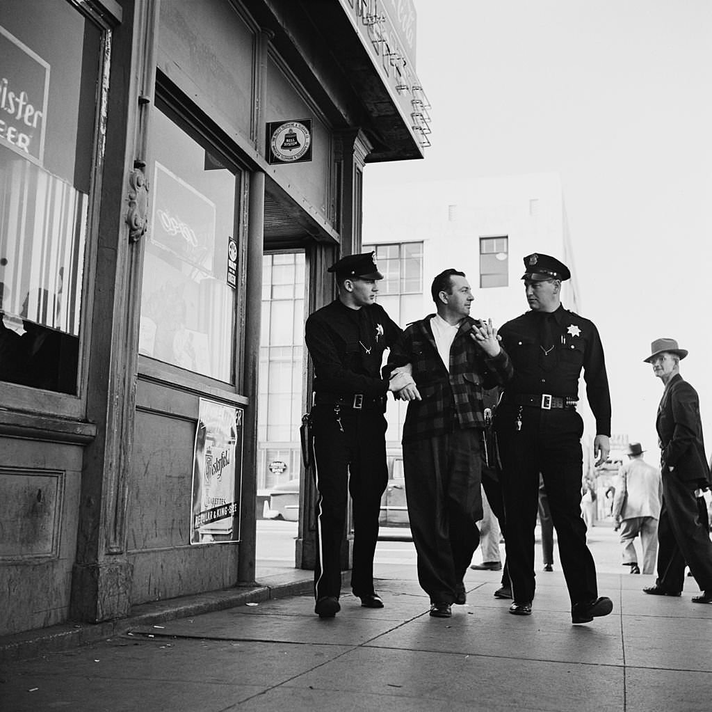 Lyle Hunt, a police officer in San Jose, California, restrains a member of the public with a fellow officer, 1954.