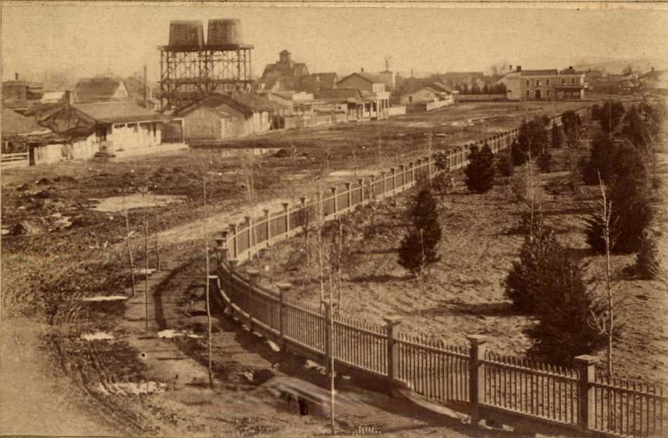 Market Street Chinatown, towers of McKenzie Iron Foundry, San Jose Brewery and San Jose waterworks are visible in background, 1866