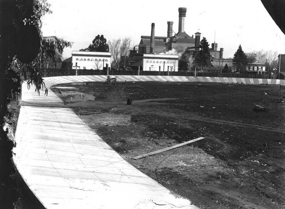 Agricultural Park bicycle track, in disrepair, with the San Jose & Santa Clara Railroad Company buildings and Fredericksburg Brewery in the background, 1951