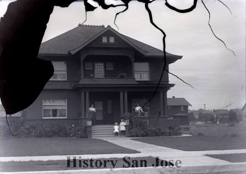 Two women and two girls on a house porch, 1890s