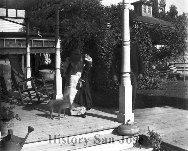 woman feeding goat on porch, 1890s