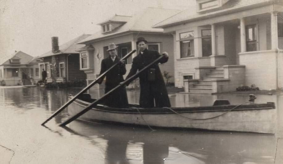 Two people rowing a boat past houses on flooded Viola Avenue. (Viola was between Market Street and Orchard Street (Almaden Road), 1911
