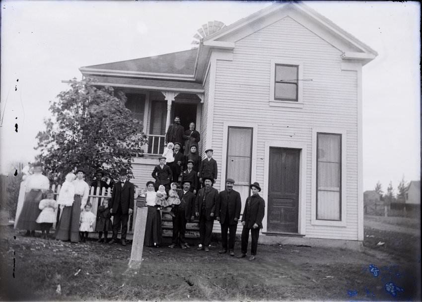 Large family in front of house, 1900s