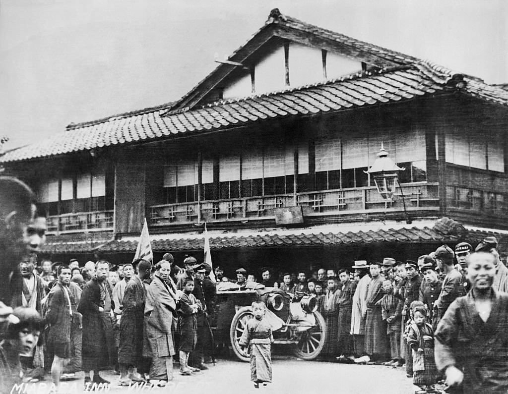 The Thomas Flyer, Victorious American car in the 1908 New York to Paris Auto Race, stopped outside an inn in Manchuria. Crowds of Chinese look on.