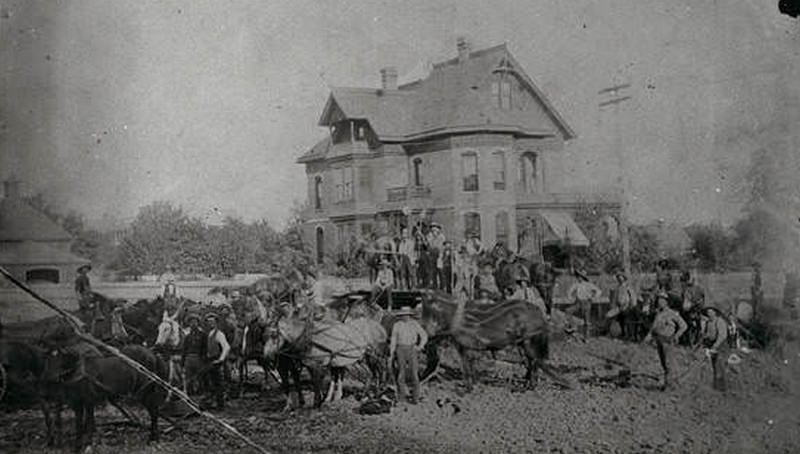 Men with horses in front of the Wall residence located at 12th and Main Street, 1880s