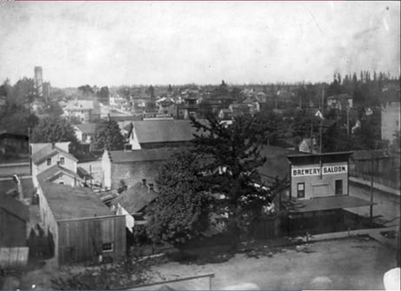 Brewery Saloon located at 1907 Washington Street in early Vancouver with the St. James Church at left in the background, 1907