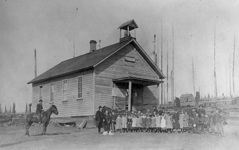 The children and a man on a horse stand in front of Eureka School House in Hockinson, 1889