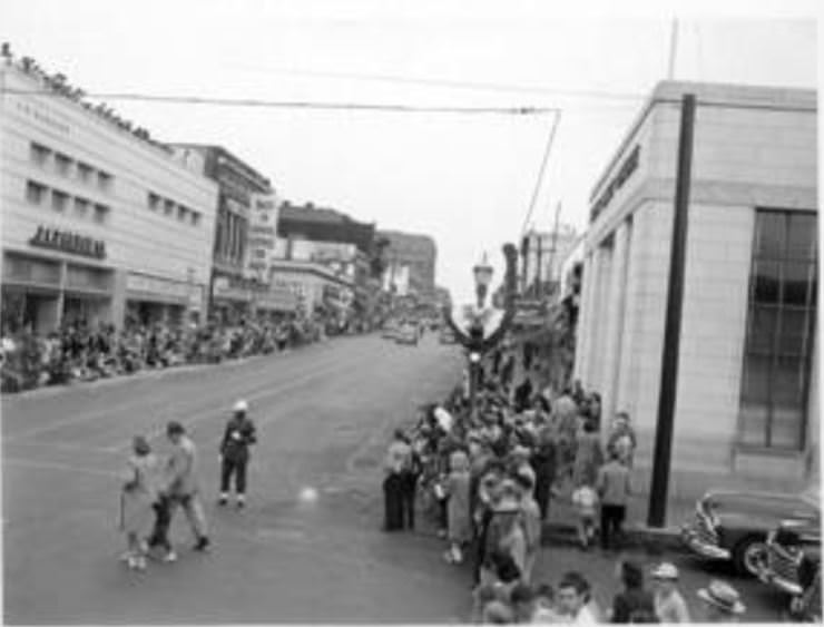 A crowd gathers along a Vancouver Street for the Cenaque Parade, 1950