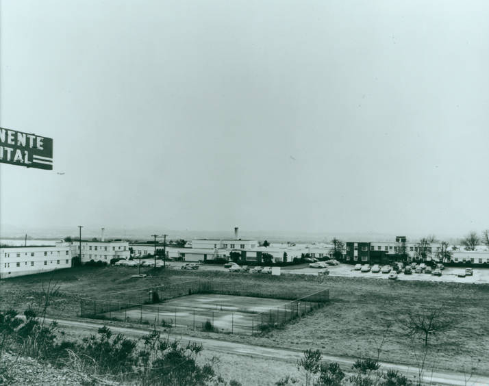 Tennis courts surrounded by cars and buildings at the Kaiser Hospital Facility in Vancouver, 1940s