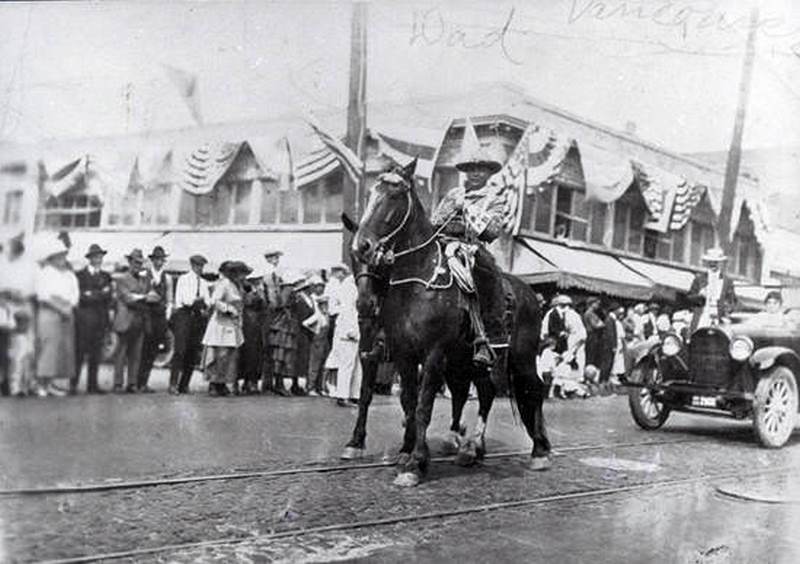 Fred Booker rides a horse during a parade in Vancouver, Washington, 1930s