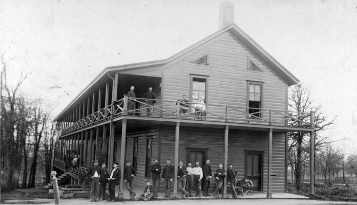 Members of the 14th Infantry are photographed on the porch of a building, 1880