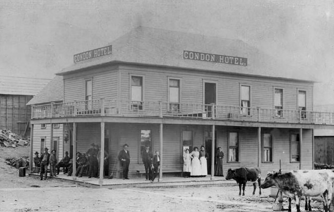 The exterior of the Condon Hotel in Vancouver, Washington with people and livestock outside the hotel, 1880s