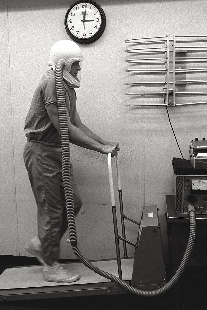 A man, wearing a helmet, is training on a tapis roulant.