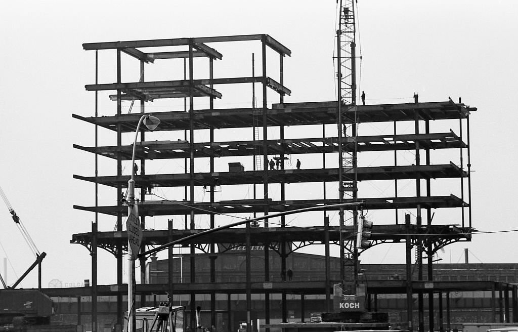 Silhouettes of construction workers can be seen on I beams, as Tower Two of the World Trade Center is erected in the winter of 1970