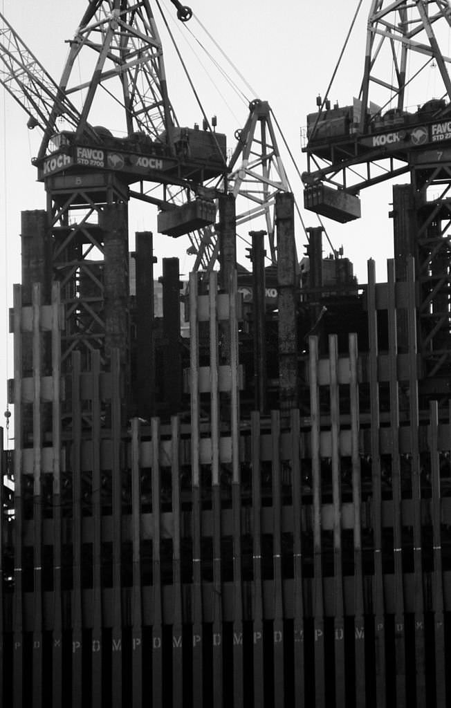 Construction cranes sit on top of a partially constructed Tower One of the World Trade Center in the winter of 1970