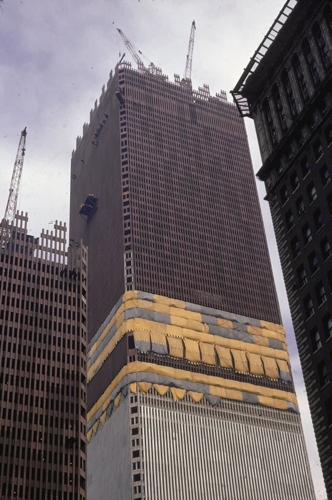 Low-angle view of cranes atop one tower of the World Trade Center during its construction, 1970.