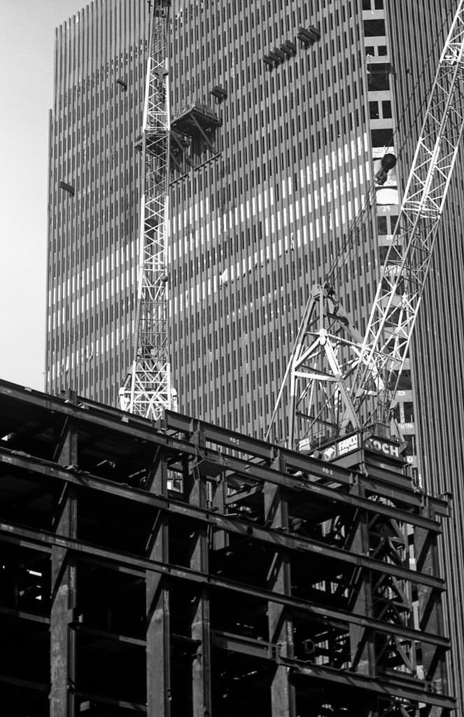 Large cranes are erected in front of tower one of the World Trade Center during construction in the Fall of 1969