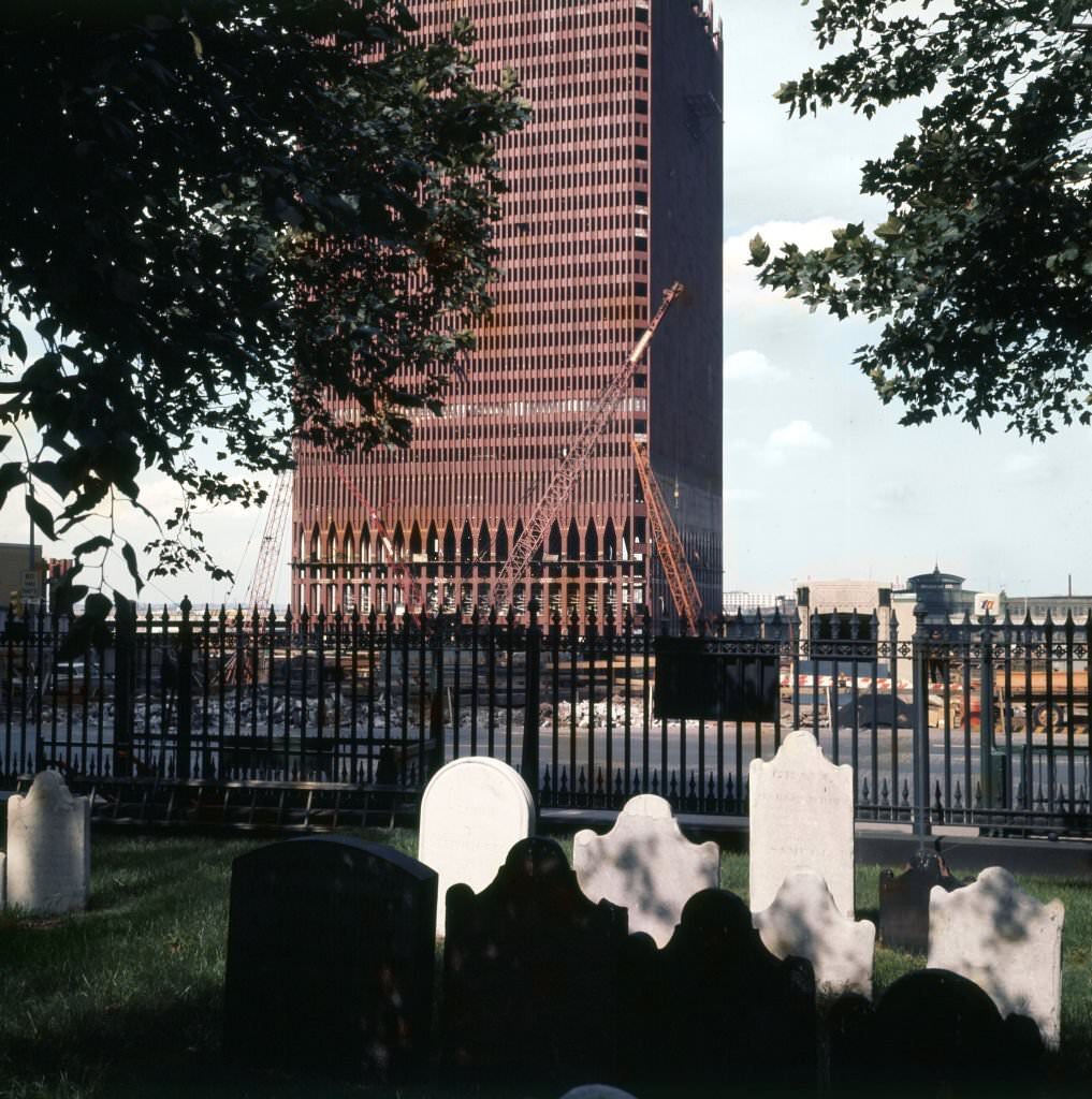 Looking west across grave stones outside St Paul's Chapel (at Church and Fulton streets), of the construction of One World Trade Center (North Tower), 1969
