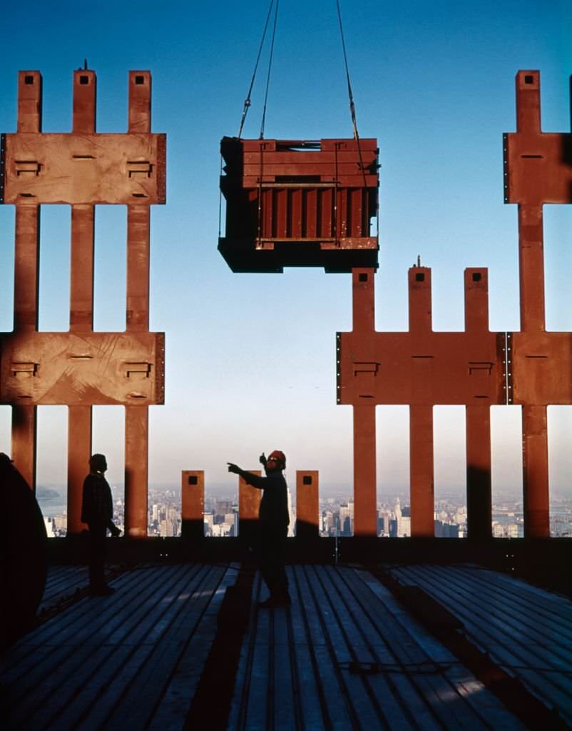 World Trade Center under construction anonymous silhouetted worker directing delivery from crane, 1970s