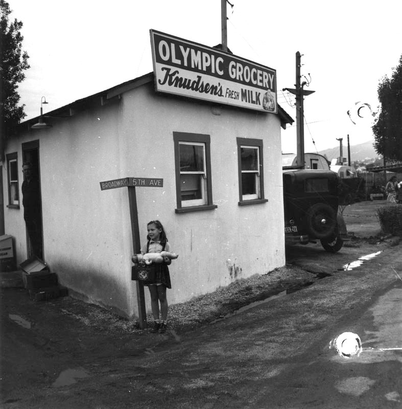 A young girl outside a market at Olympic Trailer Court.
