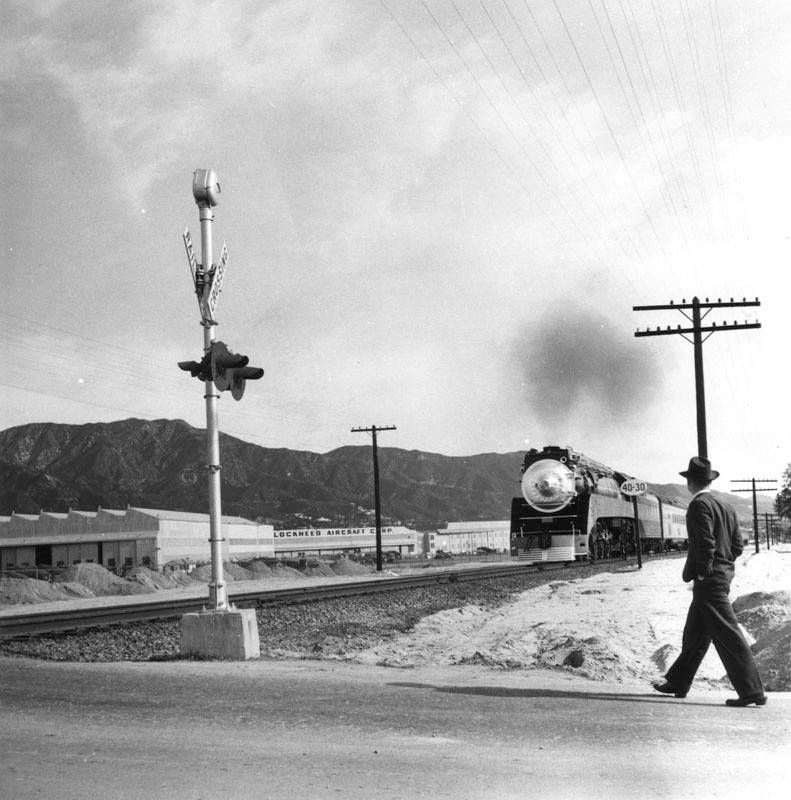 A man on an unidentified street in Burbank. In the distance is a Lockheed plant.