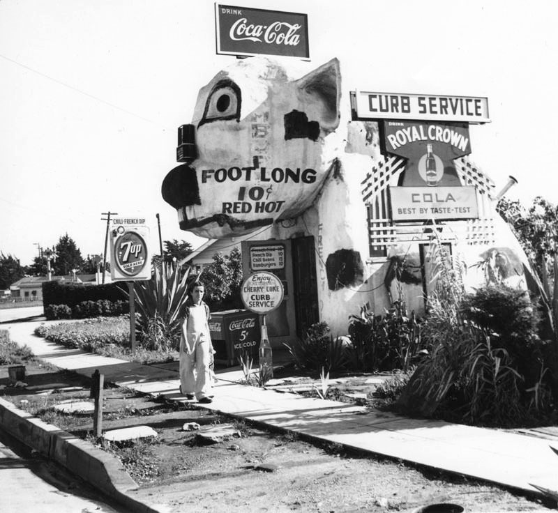 A young man walked by a hot dog stand on Washington Boulevard.