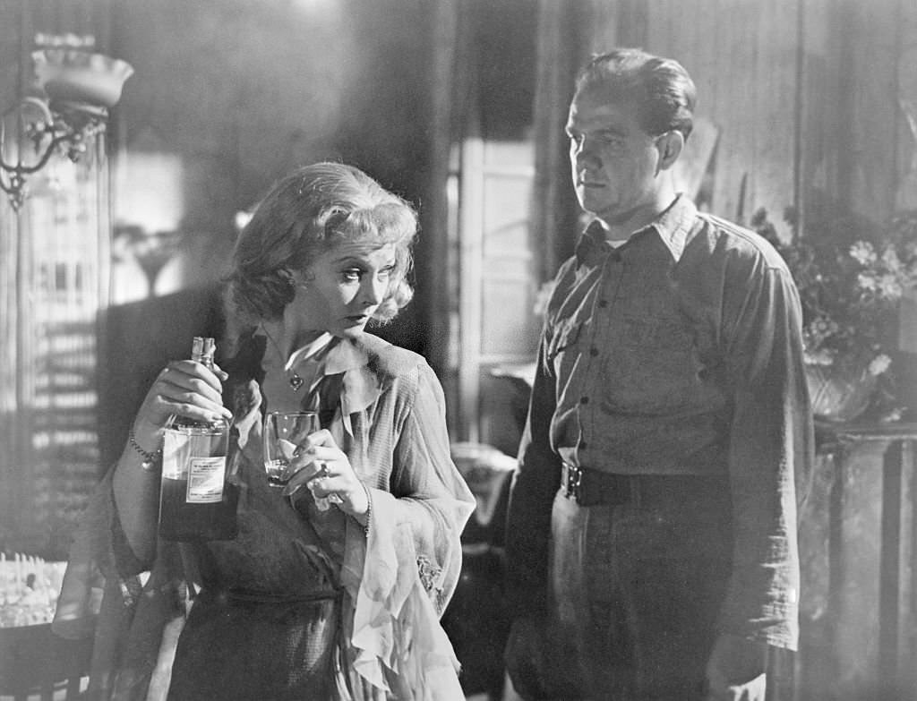 Vivien Leigh holds a glass and a bottle of gin as Karl Malden looks on in a scene from Streetcar Named Desire.