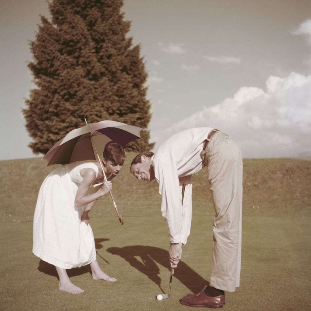 Audrey Hepburn with her husband Mel Ferrer on a golf course at the Bürgenstock resort, Switzerland, 1954.