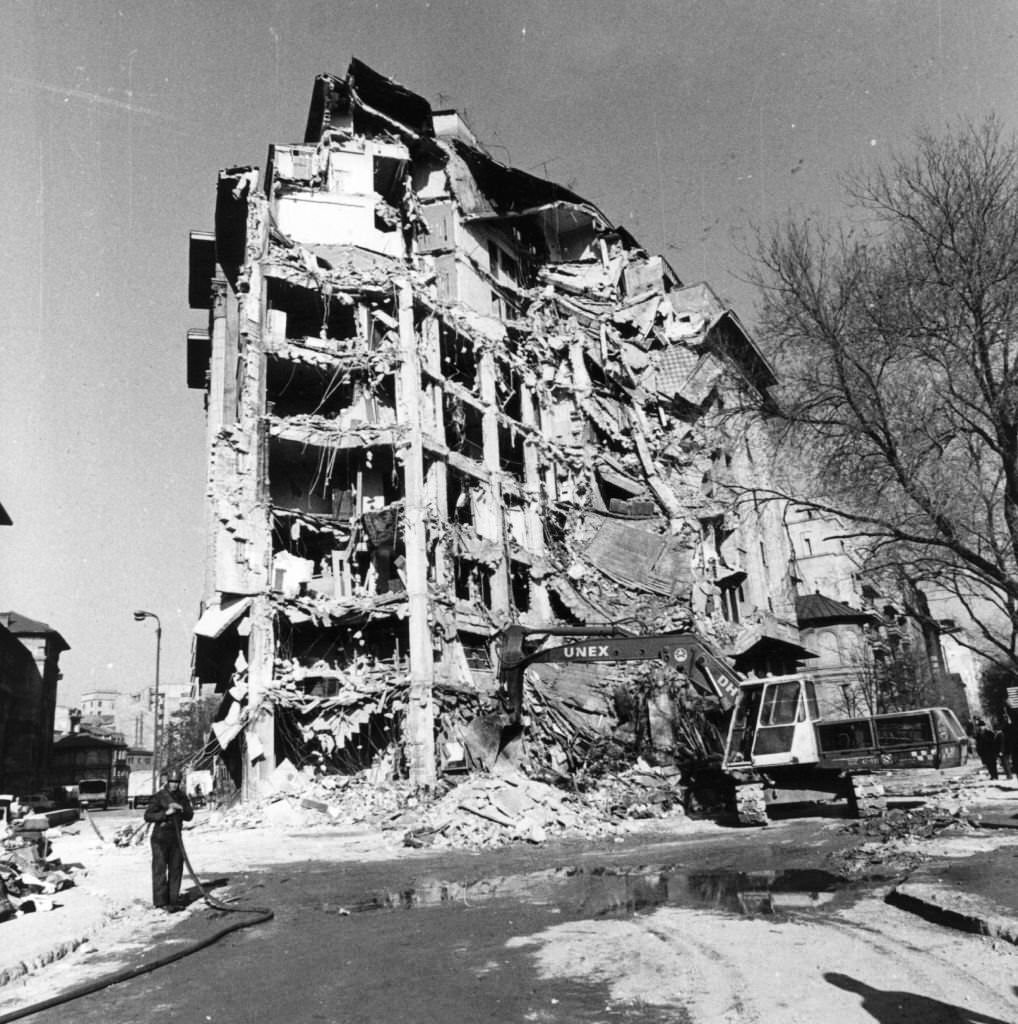 Workmen begin to demolish an earthquake damaged building in University Square, Bucharest, 1977