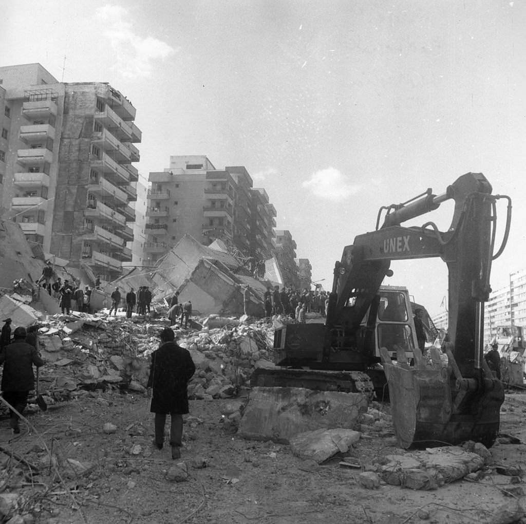 Rescue workers use a digger to sift through the remains of a block of flats after an earthquake in Bucharest which resulted in the loss of over 1,500 lives.