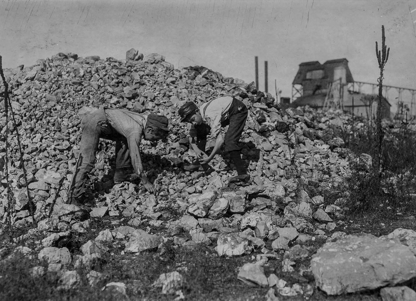 Basil Roberts and James Hopper, both 12, cull through waste from a zinc mine in Aurora, Missouri, 1910