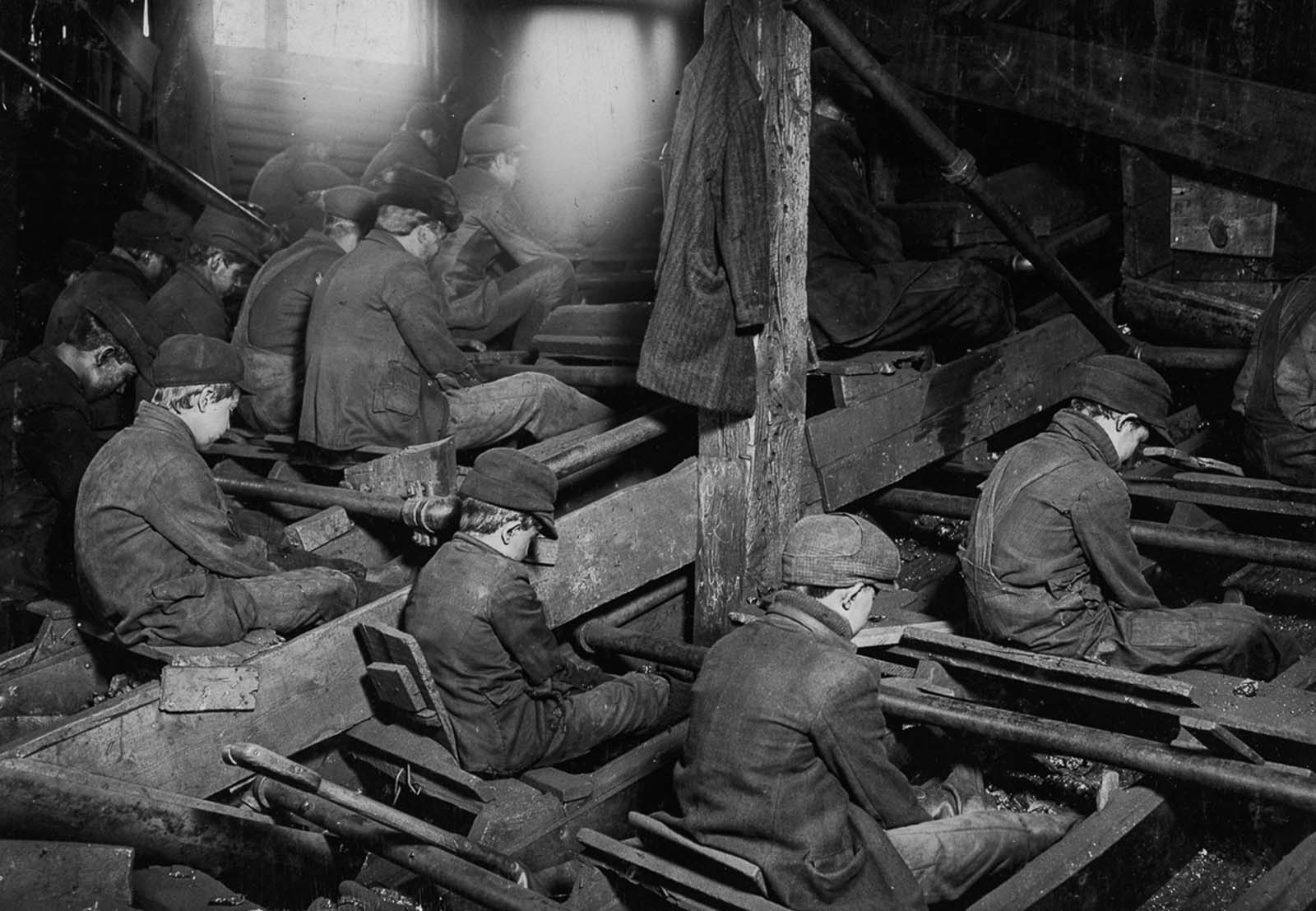 Breaker boys at work breaking coal. The process produces clouds of dust which coat the workers’ lungs, 1911