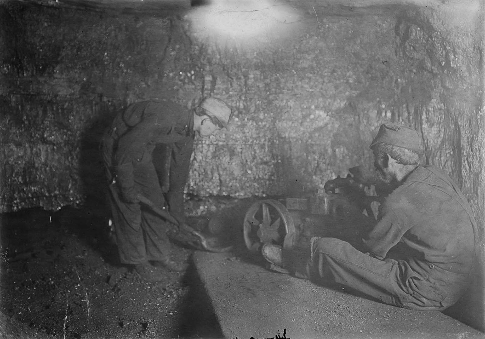 A boy shovels loose rock in a mine in Red Star, West Virginia, 1908