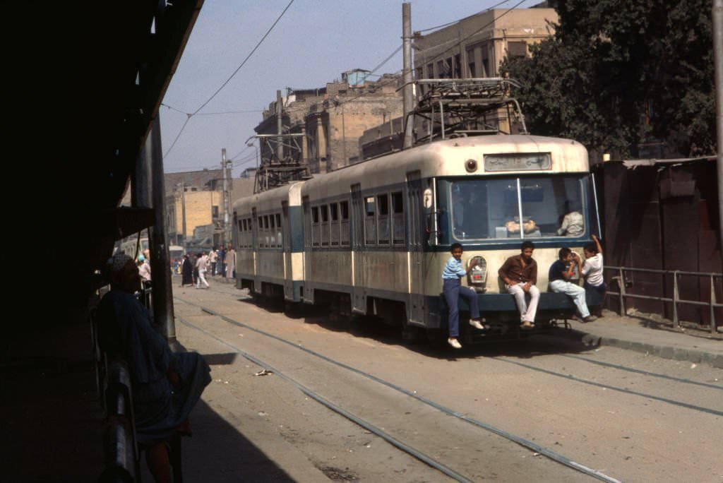 Stowaways hanging from a tramway in Cairo, 1983