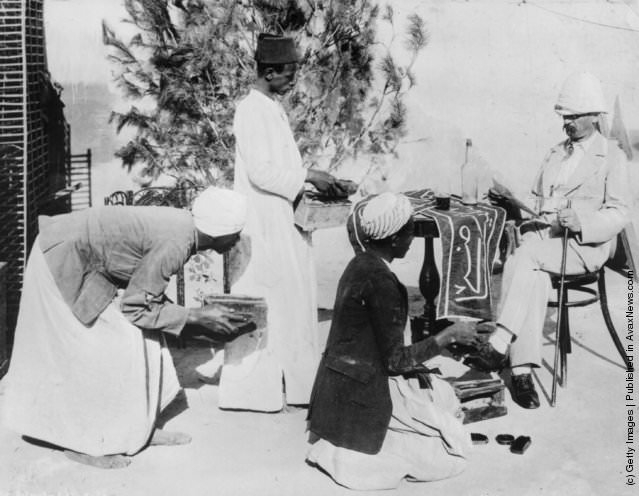Egyptian bootblacks cleaning a European's shoes in Cairo, 1870