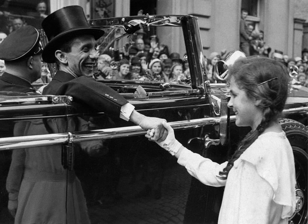 Joseph Goebbels welcomes a girl from the open, car out during a drive through Rheydt, 1934