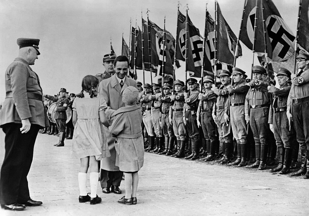 Goebbels is received by to girls at the airport Frankfurt.