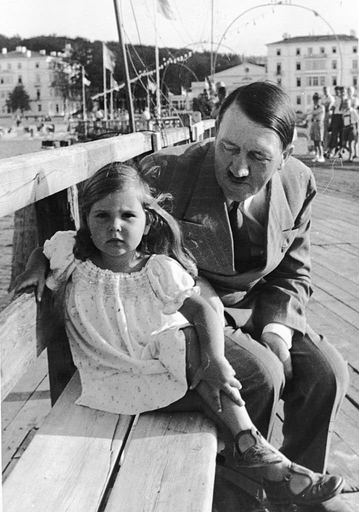 Adolf Hitler sitting on a bench with Helga Goebbels, daughter of Nazi propagandist Paul Joseph Goebbels.